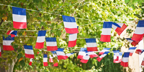 French flags garland decorating a village square French flags garland decorating a village square bastille day photos stock pictures, royalty-free photos & images