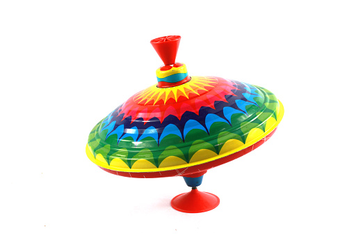 A Vintage 1970s Children's Spinning Top in Rainbow Colours on White