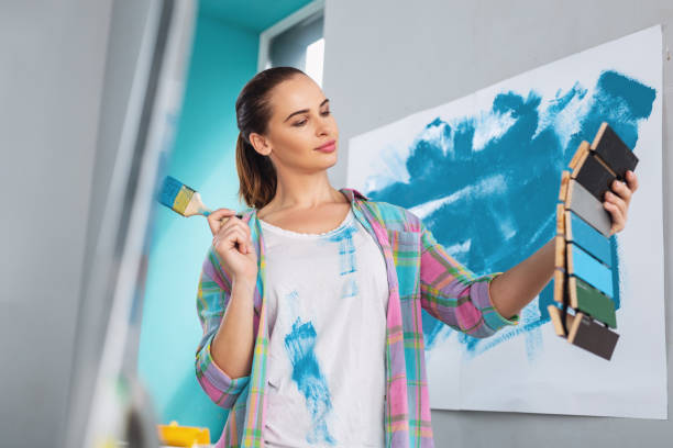 istock Joyful woman holding a colour palette 973905310