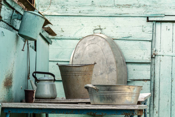 Rural life. Washstand and aluminum utensils on the background of a wooden shed.