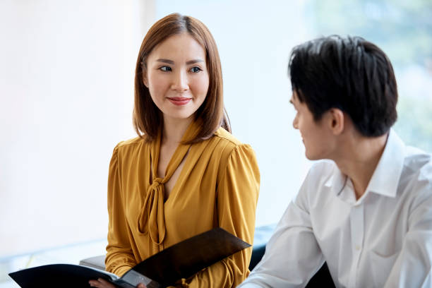 istock Smiling executive with file looking at colleague 973910868