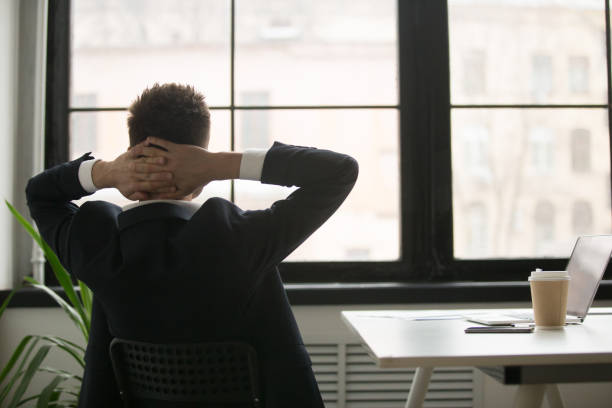 istock Rear view at relaxed businessman enjoying break resting from work 973912926