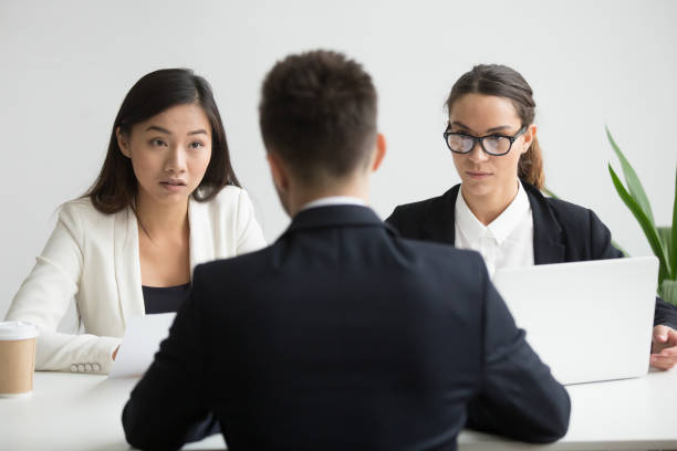 istock Serious unconvinced diverse hr managers interviewing male job applicant 973913532