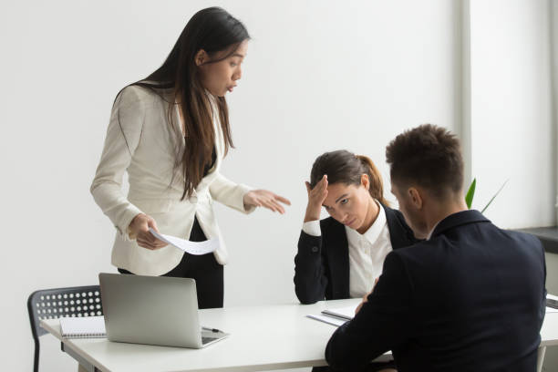 istock Angry asian executive shouting at subordinates scolding for bad results 973914804