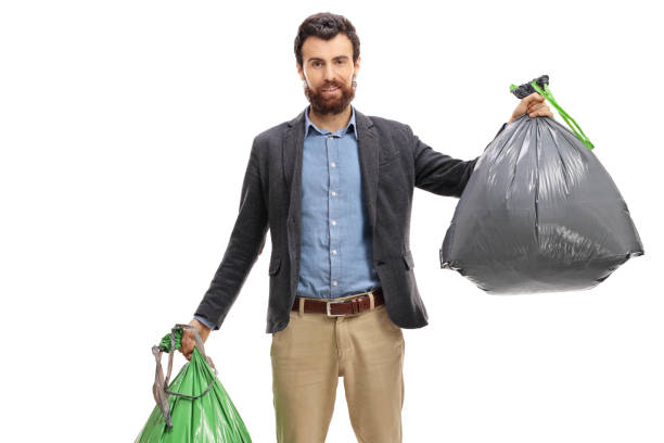 istock Young man holding trash bags 973916310