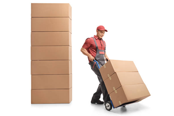istock Mover with a hand truck next to a stack of boxes 973916852