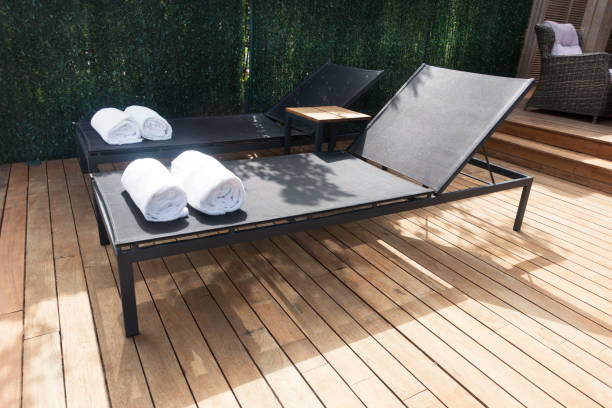 istock Deck chairs on Wooden plank floor against swimming pool 973923930