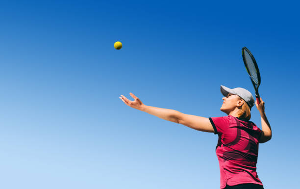 istock playing tennis, serving the ball 973925976