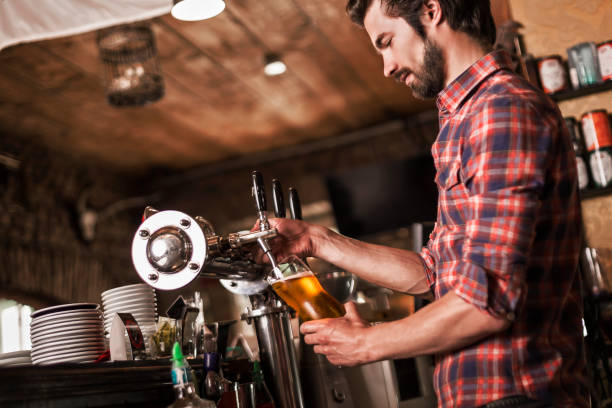 istock Bartender serving beer from beer tap in pub 973932640
