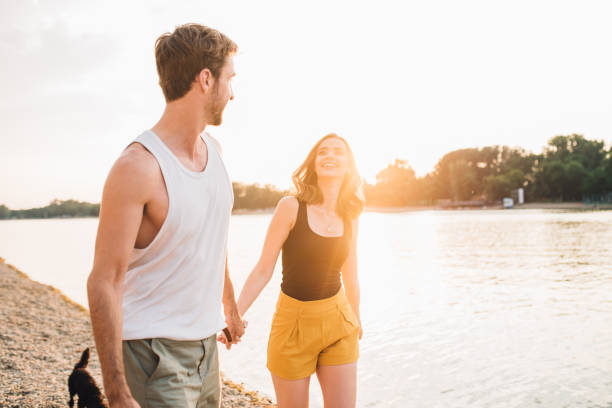 istock Young couple holding hands and looking at each other 973949010