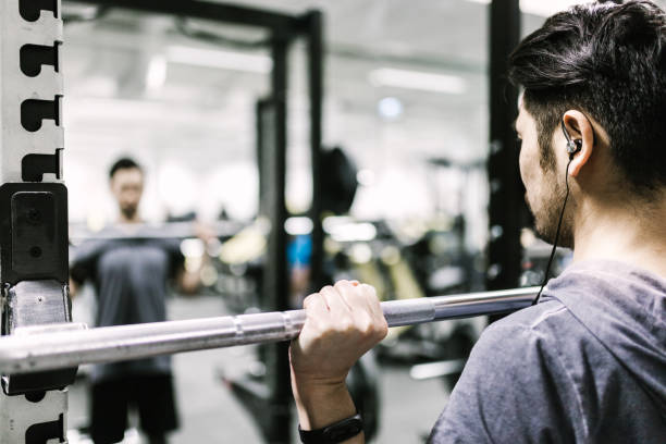 trenes con barra en el gimnasio del hombre japonés - body building exercises audio fotografías e imágenes de stock