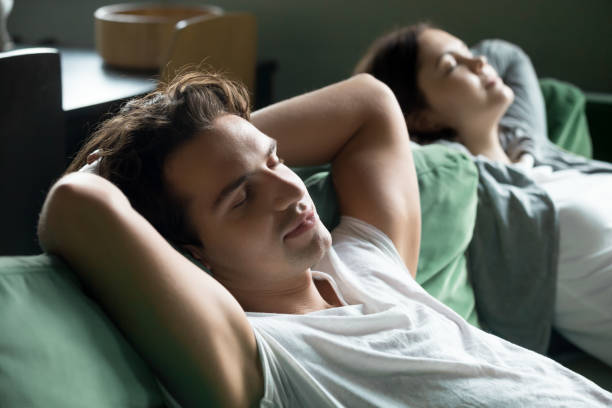 istock Young man relaxing on comfortable couch with girlfriend at home 973962160