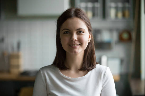 portrait de tête de femme souriante de millénaire se présentant à la maison de cuisine - beautiful indoors looking at camera cheerful photos et images de collection