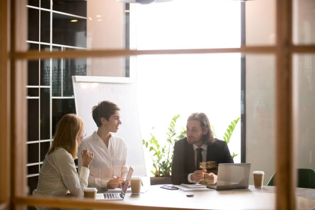 istock Smiling partners having casual talk during briefing in boardroom 973970932