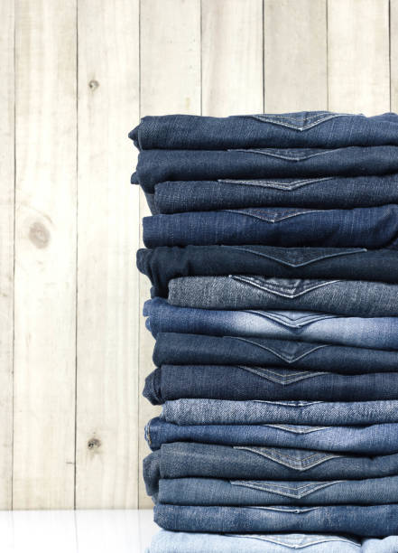 istock jeans stacked on a wooden background 973973212