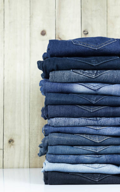 istock jeans stacked on wooden floor. blank background for design and text input. 973973410