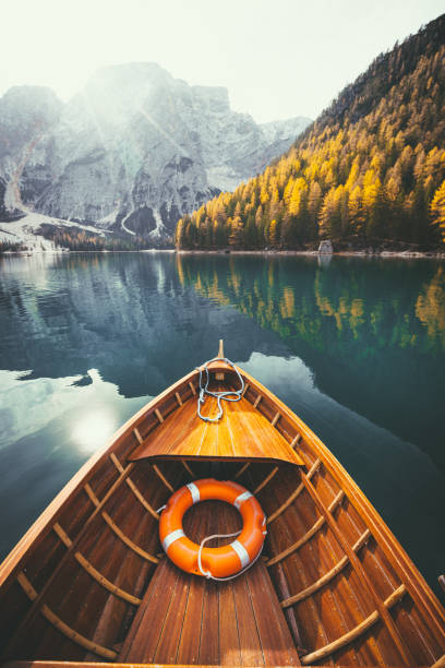 Traditional rowing boat on a lake in the Alps in fall Beautiful view of traditional wooden rowing boat on scenic Lago di Braies in the Dolomites in scenic morning light at sunrise, South Tyrol, Italy canoe photos stock pictures, royalty-free photos & images