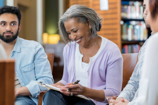 istock Senior therapist facilitates support group 973984484