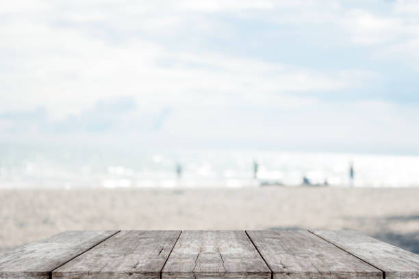 istock empty wood table on blurred of sea beach 973984572