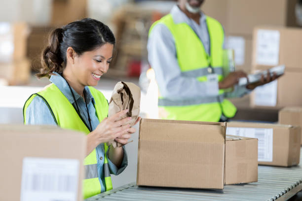 istock Distribution warehouse employee packs orders 973984884