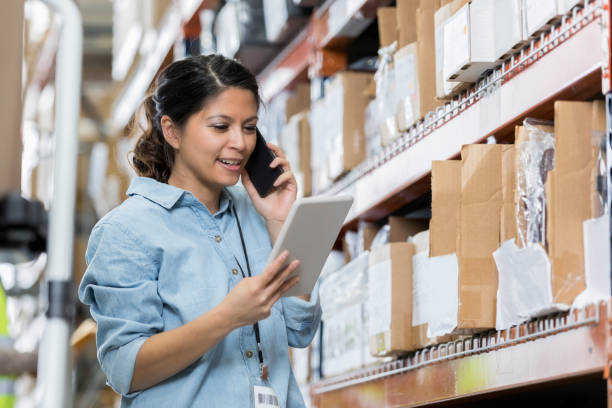 istock Warehouse manager uses smartphone 973985032