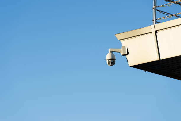 istock close up view of security camera on building facade with clear blue sky 973992816