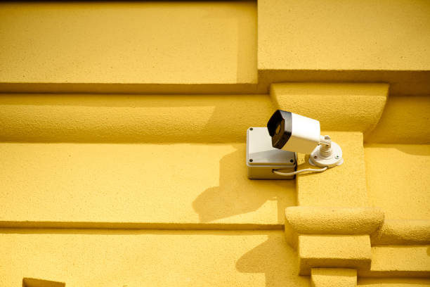 istock close up view of security camera on yellow building facade 973996536