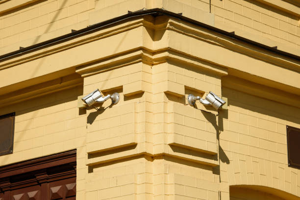 istock closeup image of security cameras on yellow building facade in sunlight 974005076