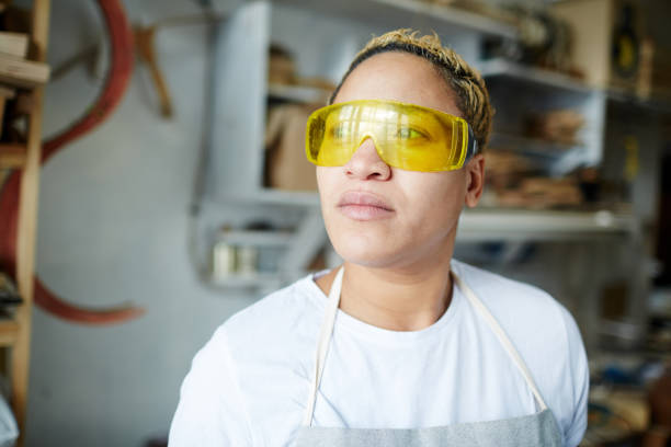 istock Female woodworker in safety goggles 974016024