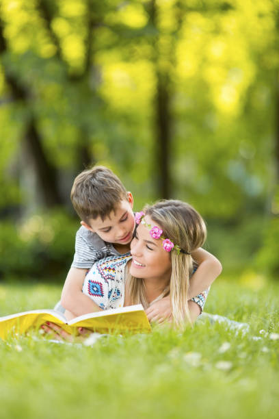 istock Mother and son in park outdoors on a blanket reading a book 974016746
