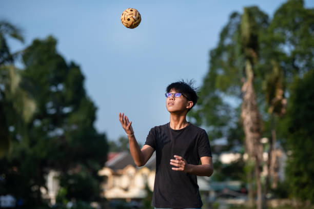 asia adolescente chino jugando sepak takraw en un día soleado - sepak takraw fotografías e imágenes de stock