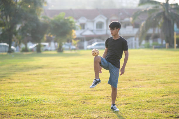 asia adolescente chino jugando sepak takraw en un día soleado - sepak takraw fotografías e imágenes de stock