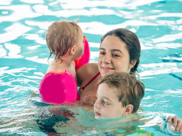 istock Mother and children in pool 974029988