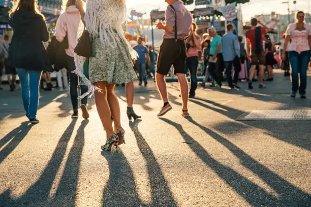 Visitors Walking Through Beer Fest Fairgrounds at sunset. Photo taken against sun in the evening.