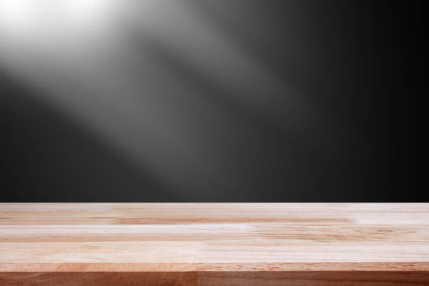 istock empty wooden on black backdrop with spotlight. Wood table top. can used for display or montage your products 974053982