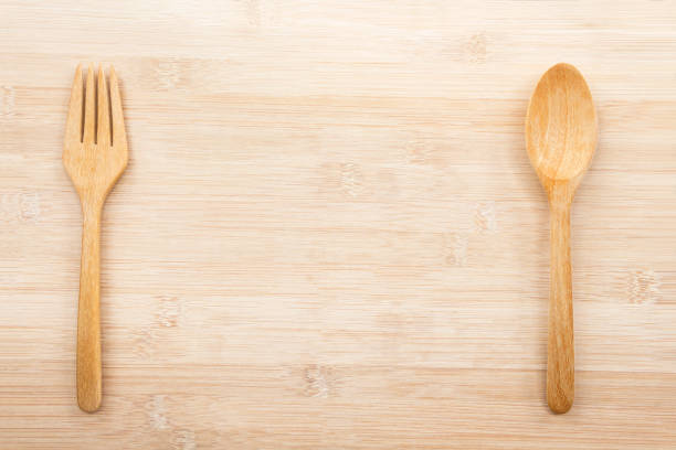 istock Spoon and fork wooden isolated on the wood table background with copy space for text. Creative layout for business food concept. 974059968