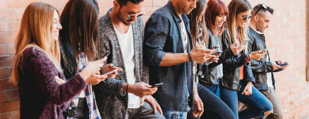 istock Group of friends using smartphone outdoors 974087210
