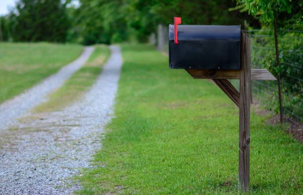 istock Rural mailbox with flag raised along a gravel road. 974091136