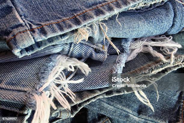 Foto de Ragged Antigo Jeans Azul Em Uma Confusão Pilha e mais fotos de stock de Jeans - Calça Comprida - Jeans - Calça Comprida, Rasgado, Jeans - Material Têxtil