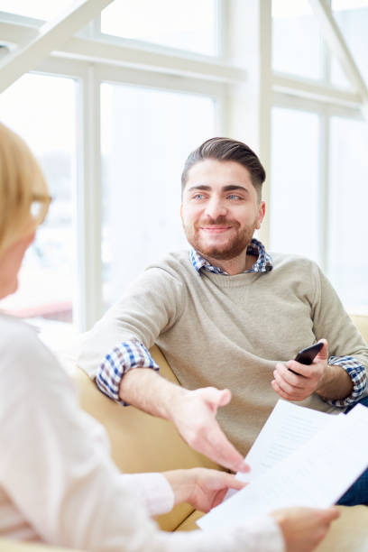 istock Smiling man having consultation with woman 974123046