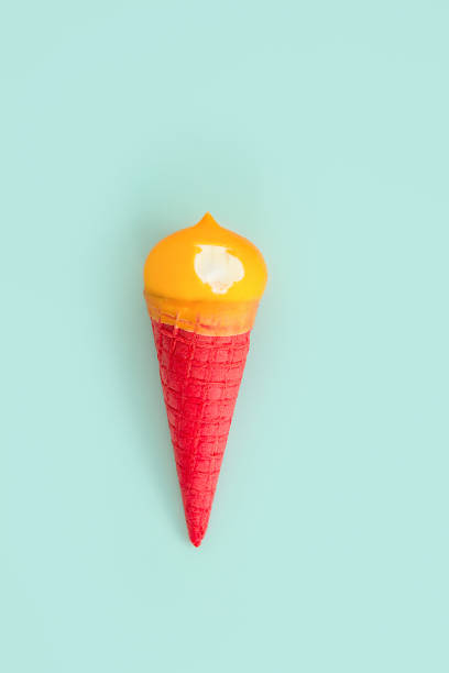 istock bit off a yellow ice cream in a red waffle cone on a blue background 974138752