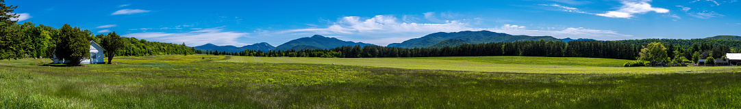 Panoramic view of a house in a glade within Adirondacks Mountains