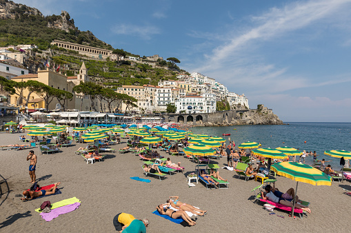 Amalfi, Italy - June 16, 2017: People are resting on a sunny day at the beach in Amalfi on Amalfi Coast in the region Campania, Italy