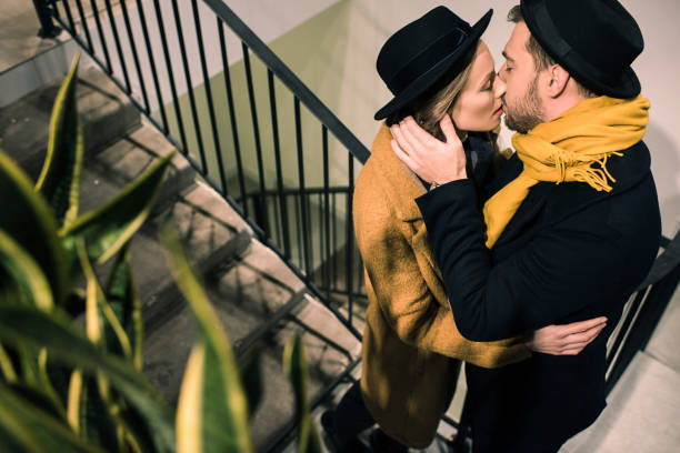istock young attractive couple kissing on stairs 974147038