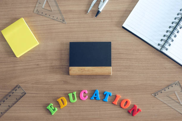 istock Top view on education school desk with small chalkboard and post note. Education colorful letters 974158748