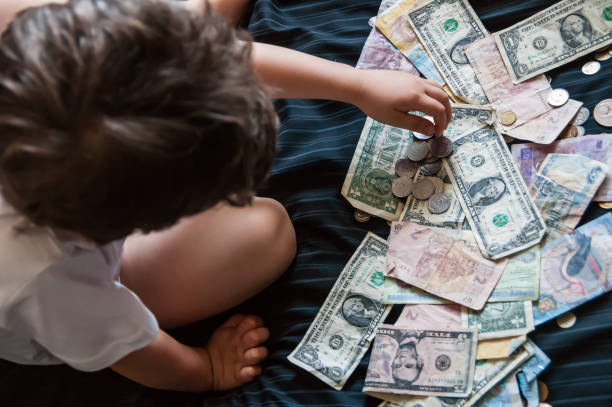 istock little boy playing with coins of different countries 974161266