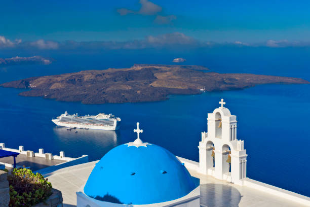 Santorini, Greece - April 23, 2018: Cruise ship ' Princess cruises ' seen from the island of Santorini with a blue dome in front