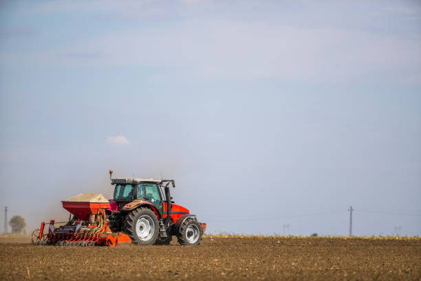 istock Farmer seeding, sowing crops at field. 974172048