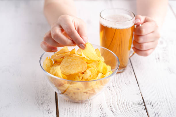 istock Relax dinner with Beer and potato Chips, female at home 974172266