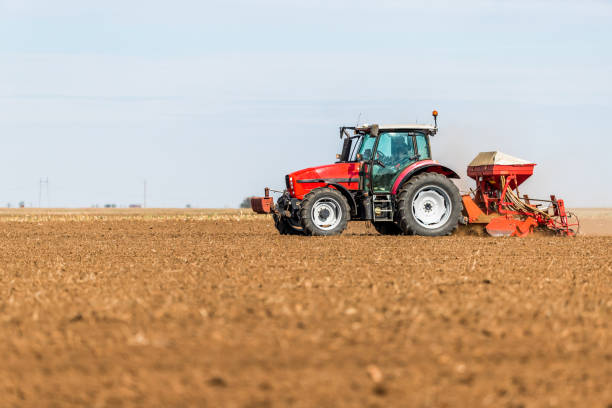 istock Farmer seeding, sowing crops at field. 974174652